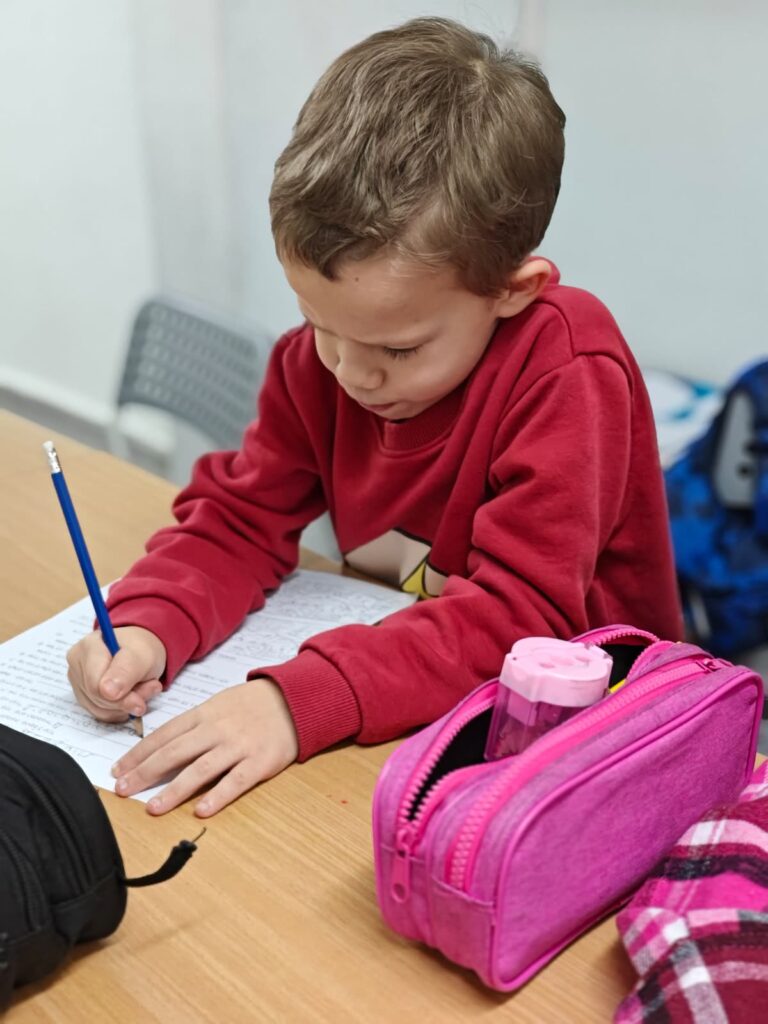 ילד כותב במחברת בשיעור ב-IQLine
